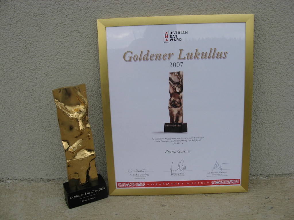 Bild des Goldenen Lukullus zusammen mit einer eingerahmten Auszeichnung.